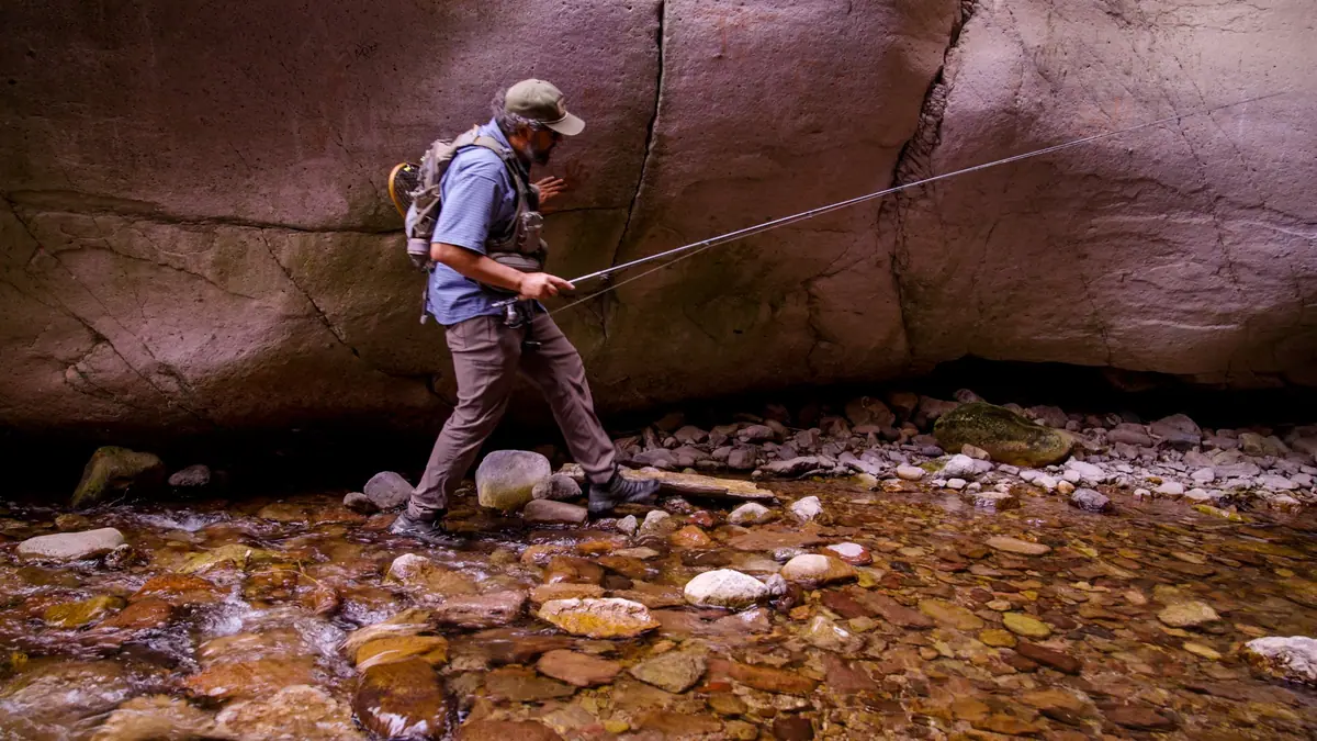 Josh Crumpton wading a canyon creek with a fly rod on the Gila in No Small Water